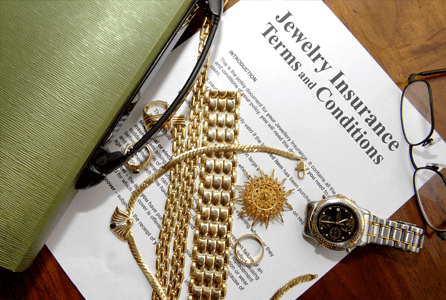 image of jewelry sitting on top of paperwork. Headline on paperwork reads: Jewelry Insurance Terms and Conditions